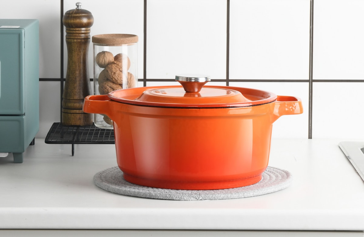 A cast-iron casserole dish styled on a kitchen worktop