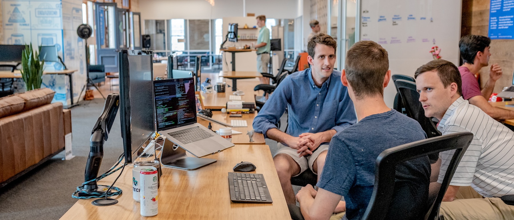 People working together at desks across a busy open-plan office